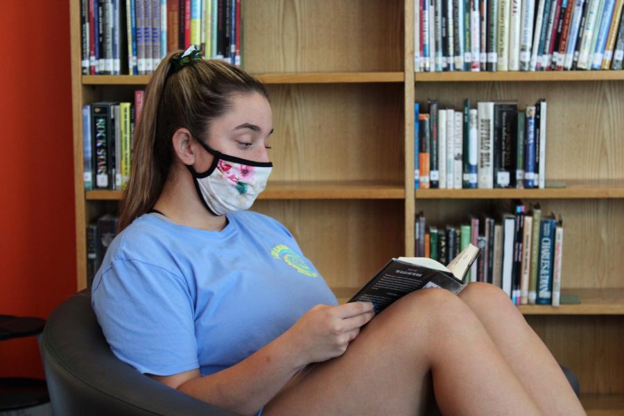 Senior Maddie Turner reads in the library. 
