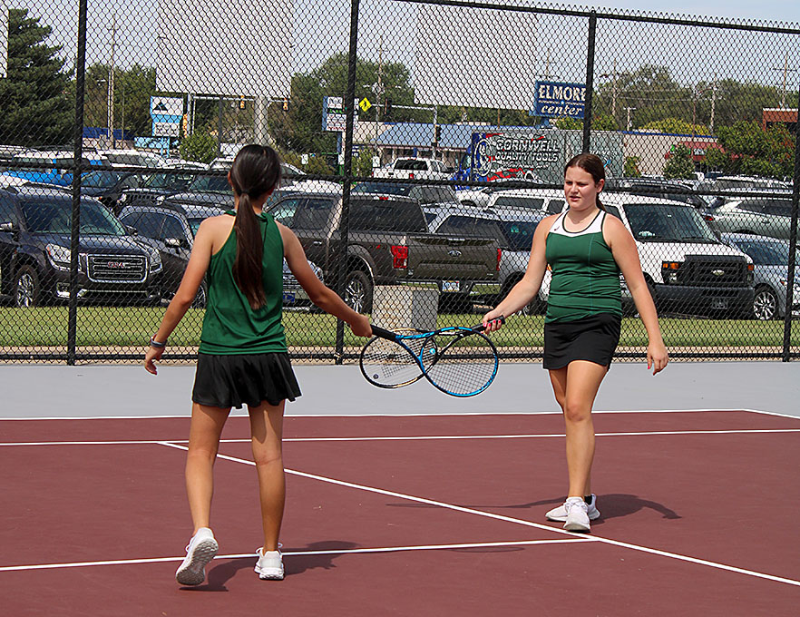 Junior Kacee Doonan and freshman Julie Lai touch racquets to celebrate a won point. 