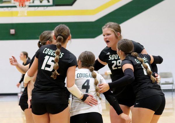 The varsity volleyball team creates a supportive environment by encouraging each other after each play. 