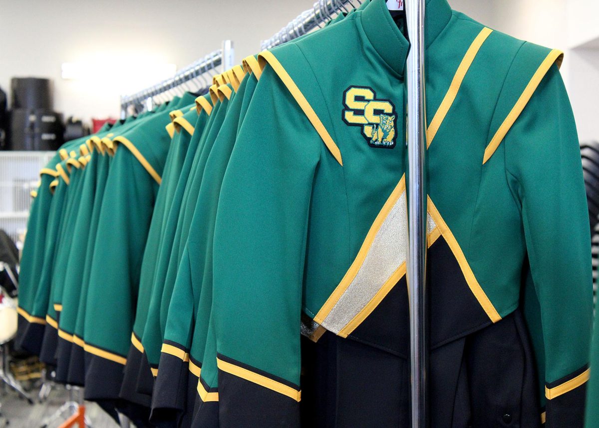 The new band uniforms wait on hangers. 