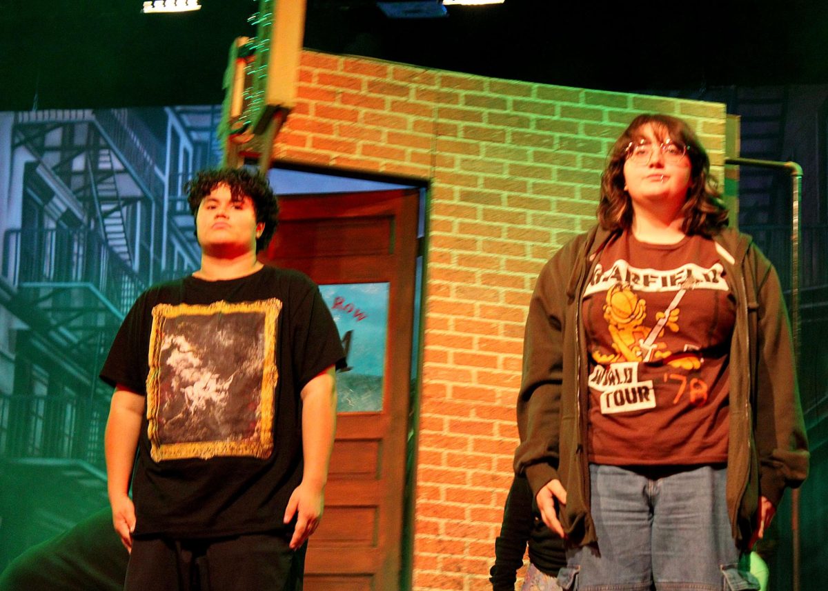 Cameron Torres ('27) and Jasper Carter ('26) stand on stage for "Little Shop of Horrors". 