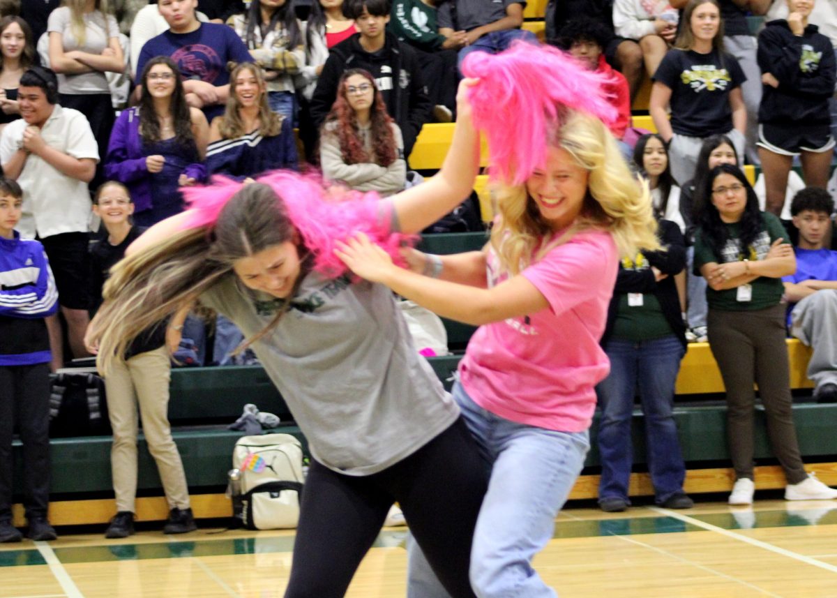 Kalliauna Johnson ('26) and Elle Barth ('26) take off each other's wigs during the wig snatch game. 