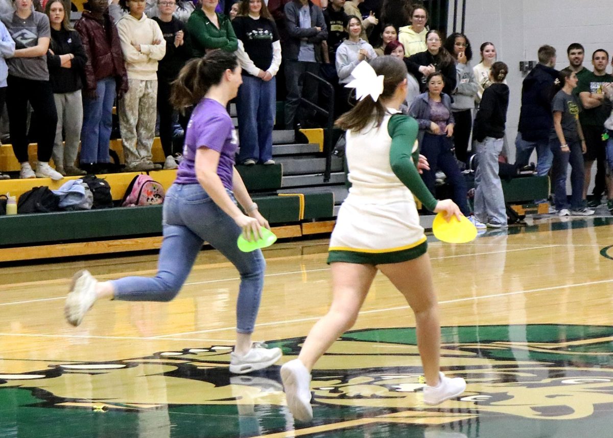 Science teacher Melissa Mahoney and Isabelah McGinty ('26) run to place their dots after making a basket. 