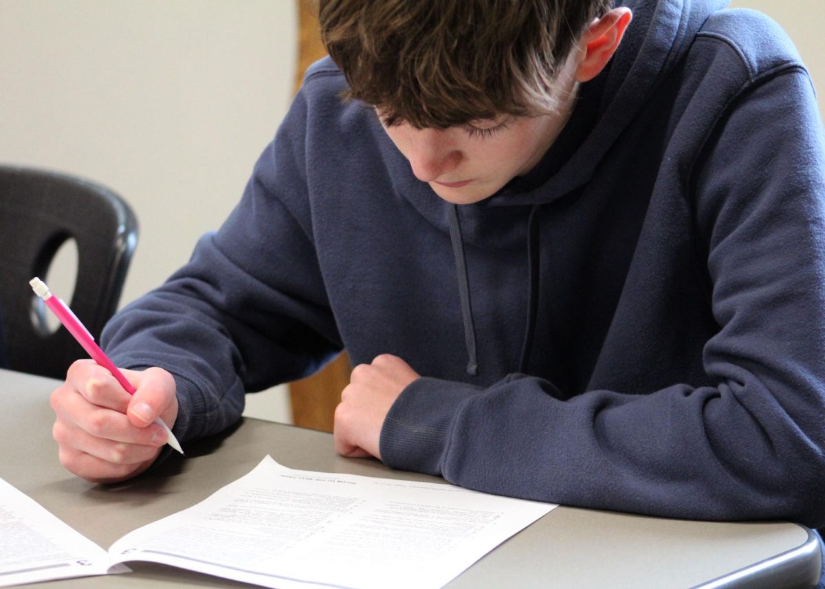 Westin Fischer ('29) reads the questions for a practice ACT reading test at an ACT prep day hosted by Gifted Coordinator Niki Chamberlain. 